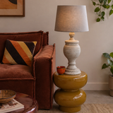 Living room with brown sofa, lamp on a yellow side table, and decorative elements.
